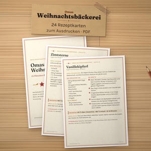 K&ouml;nnte beinhalten: Ein Set aus drei cremefarbenen Rezeptkarten mit schwarzem deutschem Text, darunter Titel wie Zimtsterne und Vanillekipferl, mit roten Sternakzenten und d&uuml;nnen roten R&auml;ndern. Ein Holzbleistift liegt rechts neben den Karten mit dem Titel Omas Weihnachtsb&auml;ckerei.