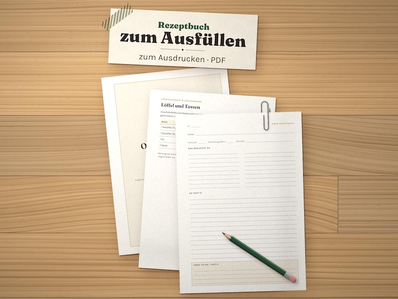 May include: A printable recipe book template featuring white sheets with black text, including the title "Rezeptbuch zum Ausf&uuml;llen" and "zum Ausdrucken &middot; PDF". The pages contain lined sections for ingredients and instructions, with a green pencil resting on top.