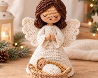 May include: A crochet angel doll with brown yarn hair, a tan face, and a gold halo, wearing a white dress with scalloped wings. The angel stands behind a small tan woven basket containing a swaddled baby doll with a tan face and closed eyes.