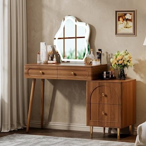 May include: A wooden vanity table with two drawers, a side cabinet featuring two additional drawers with arched detailing, gold-toned hardware, and a wavy-shaped mirror with integrated LED lighting, topped with various cosmetic bottles and a flower vase.