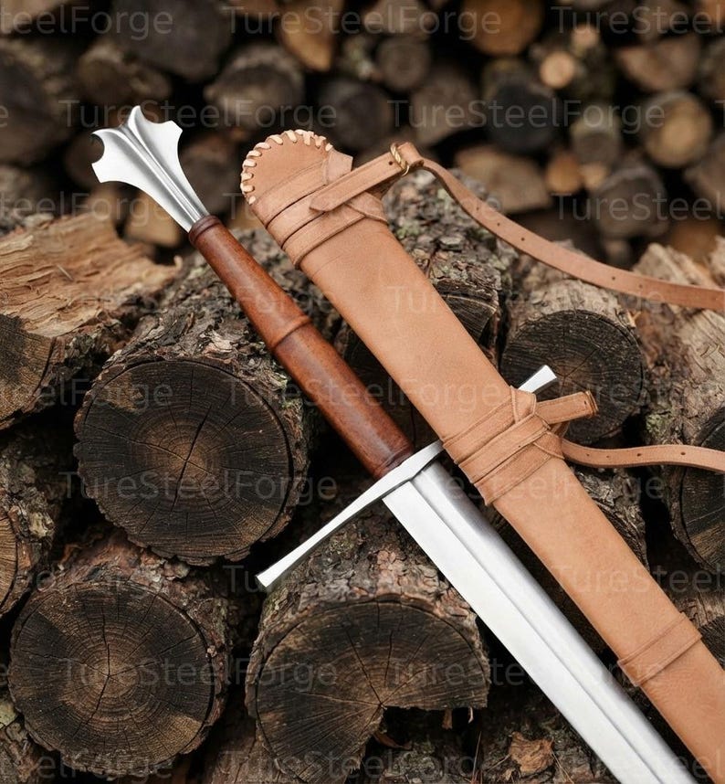 Puede incluir: Una maza con cabeza de acero pulido con bridas y mango de madera marr&oacute;n, acompa&ntilde;ada de una funda de cuero color canela con bordes cosidos y correas ajustables. La cabeza de metal tiene una forma distintiva de m&uacute;ltiples puntas.