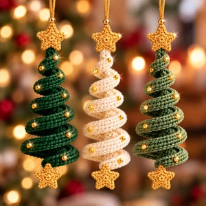 May include: Three hanging ornaments shaped like spiral Christmas trees, two in dark green and one in cream, each crocheted with a gold star at the top and bottom and small gold beads embedded along the spiral structure, suspended by gold cords.