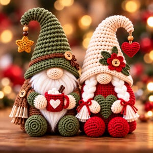 May include: Two crocheted gnome figurines. The left gnome wears a green hat with a yellow star and holds a red mug with white marshmallows. The right gnome wears a cream hat with a red flower and holds a green heart, featuring white braided hair.