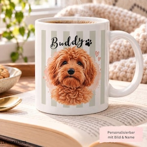Könnte beinhalten: Ein weißer Keramikbecher mit vertikalen hellgrauen Streifen und einer zentralen Illustration eines flauschigen braunen Hundes. Über dem Hund steht der Text Buddy, ergänzt durch eine Pfote und zwei kleine Herzen.