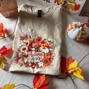 Autumn Acres tee | Squirrel eating acorns Graphic Tee, Fall T-Shirt, Festive Holiday Gift for Her, Thanksgiving holiday shirt.