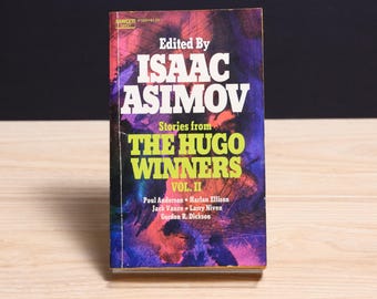 May include: A paperback book titled Stories from The Hugo Winners Vol. II, edited by Isaac Asimov. The cover features a vibrant abstract background of purple, blue, and orange hues with bold white and yellow text listing the editor and authors.