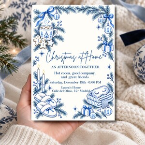 Puede incluir: Una tarjeta de invitación rectangular con ilustraciones en tinta azul de ramas de pino, adornos, una taza de cacao, galletas, velas, zapatillas y un antifaz. El texto dice: Christmas at Home, AN AFTERNOON TOGETHER, Hot cocoa, good company, and great friends. Saturday, December 19th 6:00 PM, Laura's Home, Calle del Olmo, 12 Madrid.