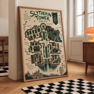 May include: A framed poster featuring a detailed floor plan of the Slytherin Tower. The illustration includes green and black ink drawings of rooms, a snake crest, and text labels like Dormitory, Common Room, and Potions Study Area on a cream background.