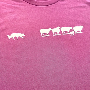 May include: A pink t-shirt with a white silhouette of a dog herding a line of sheep.