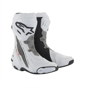 Puede incluir: Un par de botas de carreras para motocicleta en blanco y negro con paneles perforados, un logotipo negro de Alpinestars en la espinilla superior y el texto Supertech impreso en rojo y negro en el lateral del talón y la estructura de soporte.