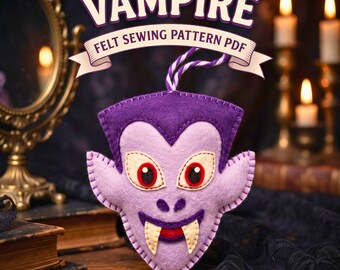 May include: A purple felt vampire head ornament with a dark purple widow's peak, large white eyes with red pupils, and two white fangs. The text VAMPIRE FELT SEWING PATTERN PDF is displayed above the ornament, which hangs from a purple and white string.