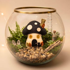 Felt mushroom house ornament on an autumn tree stump with fallen leaves