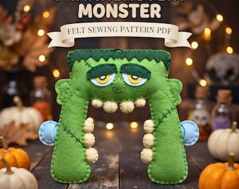 May include: A green felt Frankenstein monster shape with yellow eyes, beige teeth, and dark green stitched details. The text above reads FRANKENSTEIN MONSTER FELT SEWING PATTERN PDF. The object features a flat top, two downward legs, and small blue circular accents on the sides.