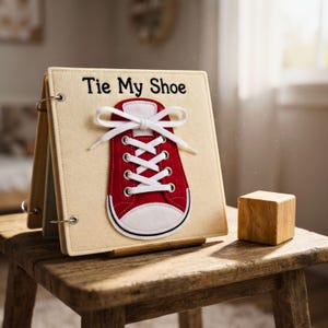Travel-friendly handmade felt quiet book page featuring a lace-up shoe set up on a small child's table.