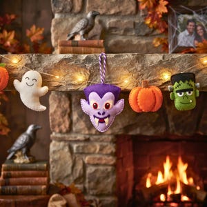 Lavender felt vampire ornament on a Halloween garland with ghost, pumpkin and Frankenstein ornaments over a fireplace.