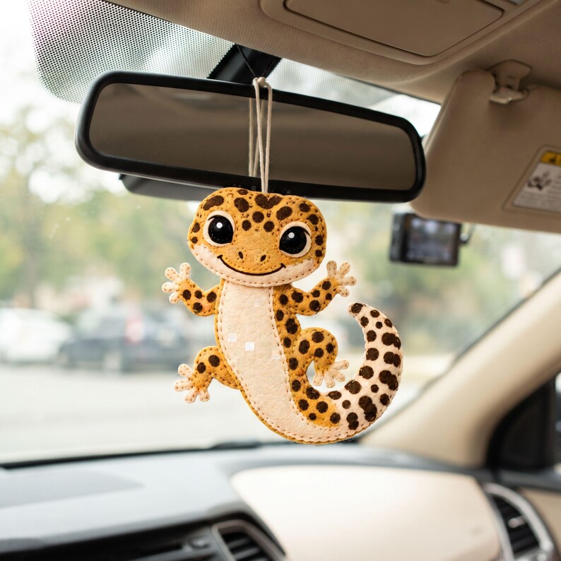 Finished leopard gecko felt ornament displayed as handmade décor, showing its spotted yellow body, cream chest, four feet, and curled tail.