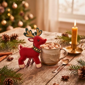 Hand holding small felt reindeer ornament showing size scale for Christmas tree decoration