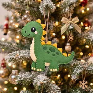 Close-up of a kawaii felt dinosaur face with black eye, small white eye highlight, optional pink cheek, embroidered nostril and smiling mouth.