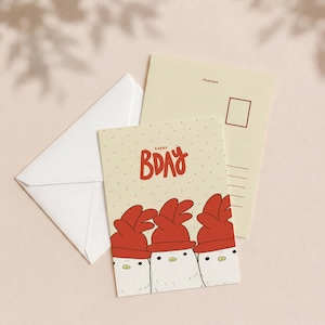 Puede incluir: Una tarjeta de felicitación de color crema con tres pollos blancos de crestas rojas y el texto rojo "HAPPY BDAY" encima, acompañada de un sobre a juego y el reverso de una postal con un recuadro para sello y líneas de dirección.