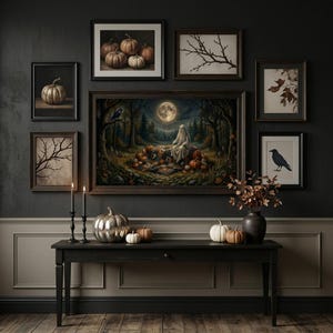 Op de afbeelding: Een zwarte sidetable bevat een zilveren pompoen, een witte pompoen, een oranje pompoen, een witte pompoen en een donkere vaas met takken. Erboven hangt een galerijmuur met ingelijste kunst van pompoenen, bomen, een kraai en een geest in een bos.