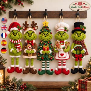 May include: Five crocheted green characters hanging on a wooden rack. The figures wear various holiday outfits including a Santa hat, reindeer antlers, a Christmas tree costume, a chef apron with a gingerbread cookie, and a black top hat.