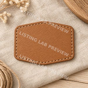 May include: A tan, shield-shaped patch with a textured surface and rounded corners, featuring light-colored stitching along the entire perimeter. The text LISTING LAB PREVIEW is repeated diagonally across the surface of the patch.