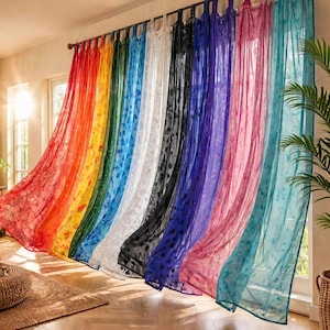 Op de afbeelding: Een reeks transparante, kamerhoge gordijnen die aan een roede hangen, met een levendig kleurenspectrum waaronder rood, oranje, geel, groen, blauw, wit, zwart, paars, roze en taling, elk met een delicaat, herhalend bloemenpatroon.