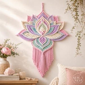 Könnte beinhalten: Ein Wandbehang mit einem großen, kunstvollen Makramee-Lotusblütendesign. Das Stück ist aus Baumwollkordel in Pastelltönen wie Rosa, Lavendel, Mintgrün und Creme gefertigt und hat eine lange, rosa Fransenquaste, die in der unteren Mitte hängt.