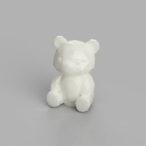 Può includere: Una statuetta a forma di orso di colore bianco tinta unita, caratterizzata da un design geometrico a facette. L'orso è raffigurato in posizione seduta con le zampe anteriori rivolte in avanti, con una finitura liscia e lucida sulla struttura.