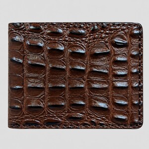 Puede incluir: Una cartera rectangular plegable con un exterior de color marrón oscuro brillante y un patrón texturizado en relieve que imita la apariencia de la piel de cocodrilo. La superficie muestra una cuadrícula repetitiva de escamas.
