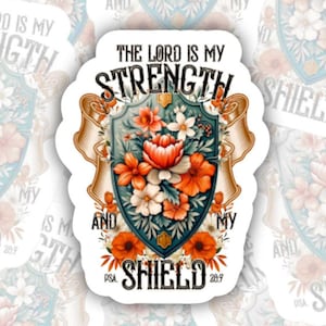 May include: A sticker featuring a shield design with floral elements in shades of orange, white, and pink. The text "THE LORD IS MY STRENGTH AND MY SHIELD" is displayed. The sticker has a white border and is surrounded by similar stickers.