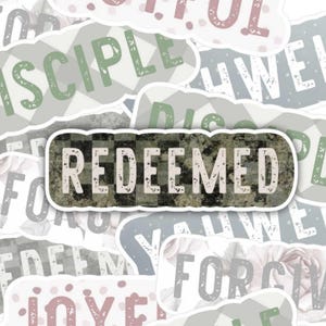 May include: A collection of stickers with inspirational words like "Joyful", "Disciple", and "Redeemed". The stickers have a variety of colors, including pink, green, and gray, and feature floral and checkered patterns. The words are in a handwritten style.