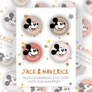 May include: A set of 10 round, colorful, printed buttons featuring Mickey Mouse. The buttons are decorated with gold glitter and the text "Walt Disney World Passholder". The buttons are arranged in a random pattern on a white background. The text "Jack & Maverick" is printed on the bottom of the image.