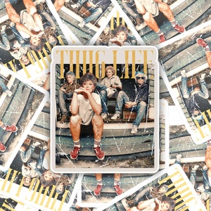 May include: A set of nine stickers featuring a vintage-style photo of a group of people sitting on a porch. The photo is surrounded by a distressed white border and the words "THUG LIFE" are printed in gold letters at the top.