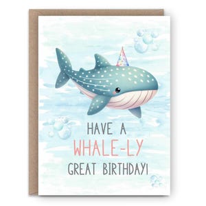 May include: A birthday card featuring a cartoon whale with a party hat. The whale is light blue with white spots, swimming in a blue watercolor background. The card reads "Have a Whale-ly Great Birthday!" in pink and gray text.