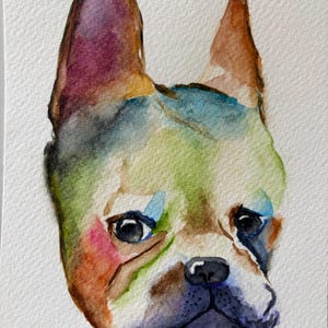 May include: A watercolour painting of a French Bulldog head featuring vibrant, blended washes of green, blue, purple, and orange. The dog has large, upright ears, dark expressive eyes, and a black nose, rendered with soft, bleeding edges.