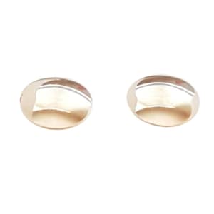 May include: A pair of round, polished gold-tone stud earrings with a smooth, reflective surface. Each earring features a domed, circular shape that catches the light, creating a bright, metallic sheen across the curved, convex front face.