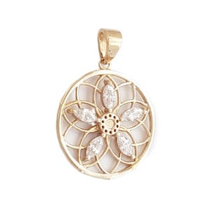 May include: A circular gold pendant featuring an openwork lattice design. The centre is adorned with five marquise-cut clear stones arranged in a floral pattern, with a small circular gold detail at the very centre of the stone arrangement.