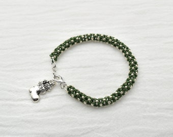 Christmas Bracelet, Green and silver seed beads woven into a beaded rope with a holiday charm, closing with a lobster claw clasp