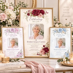 May include: Three framed memorial signs titled Celebrating Her Life with photos of Evelyn Grace Carter. The centre sign features burgundy roses, while the side signs display purple and blue floral arrangements, all printed on cream paper.