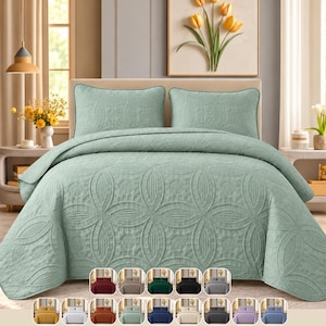 May include: A sage green bedspread set featuring two matching pillow shams, all decorated with a repeating embossed circular and oval geometric pattern. The set is displayed on a bed, with a small color palette of various available shades shown below.