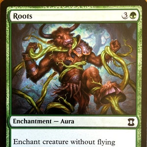 May include: A green Magic: The Gathering card with the name "Roots" and the text "Enchant creature without flying. When Roots enters the battlefield, tap enchanted creature. Enchanted creature doesn't untap during its controller's untap step."