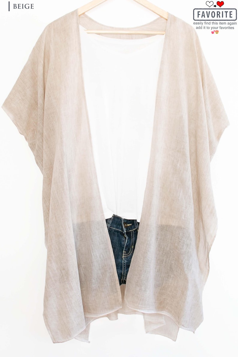 May include: Beige open-front kimono-style cover-up over a white top and denim shorts. The cover-up is made of a lightweight fabric and hangs on a wooden hanger. The word "FAVORITE" is in a box in the upper right corner.