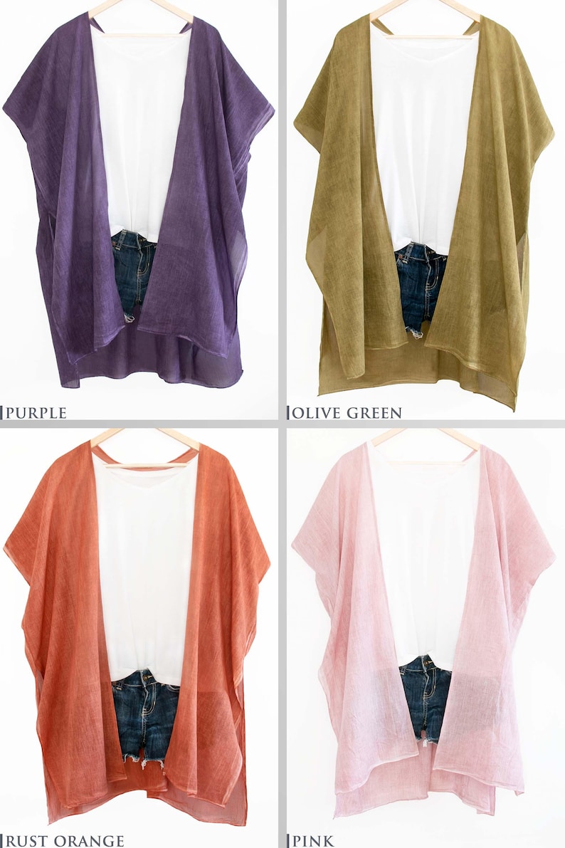 May include: Four open-front cover-ups in purple, olive green, rust orange, and pink. Each is paired with a white top and denim shorts. The cover-ups are hanging on wooden hangers against a white background.