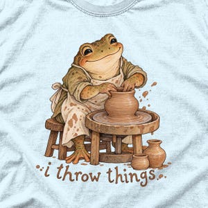 物を投げるカエルの陶芸家コンフォートカラーズTシャツ｜面白い陶芸Tシャツ