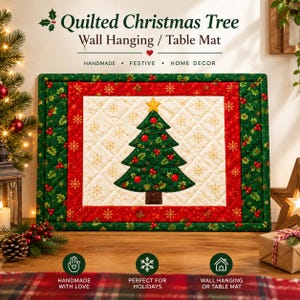 May include: A rectangular quilted wall hanging or table mat featuring a central cream panel with a green Christmas tree, red ornaments, and gold snowflakes. The border consists of red and green fabric with holly and berry patterns.