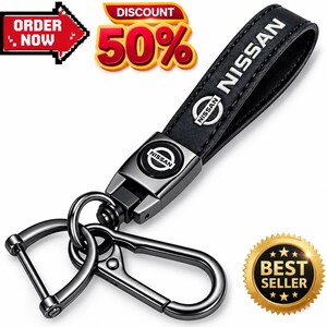 May include: A black leather keychain featuring the Nissan logo in white text on the strap and a circular metal emblem. It includes a dark metallic D-ring and a spring-loaded carabiner clip. The image contains text reading ORDER NOW, 50%, and BEST SELLER.