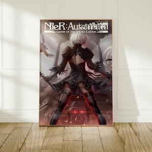 Peut inclure: Une affiche verticale présentant le titre NieR:Automata Game of the YoRHa Edition en haut. L'illustration montre un personnage aux cheveux blancs vu de dos, portant une robe noire et des bottes hautes, tenant deux épées dans un décor sombre.