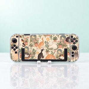 Può includere: Una console di gioco portatile con una skin decorativa caratterizzata da un motivo di vari gatti, piante in vaso e lune crescenti. La console presenta pulsanti neri, joystick e un supporto nero, su uno sfondo chiaro con accenti floreali.