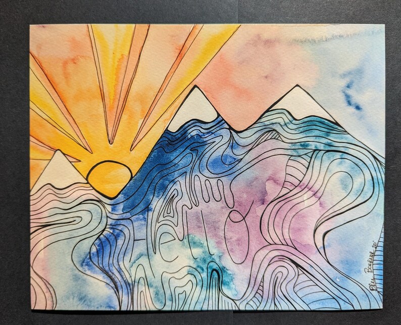Op de afbeelding: Aquarel schilderij van een berglandschap met een opkomende zon. Het kunstwerk toont een levendige oranje en gele lucht, blauwe en paarse bergen en het woord "hello" in het midden. Zwarte inkt omlijnt de bergen en het water.